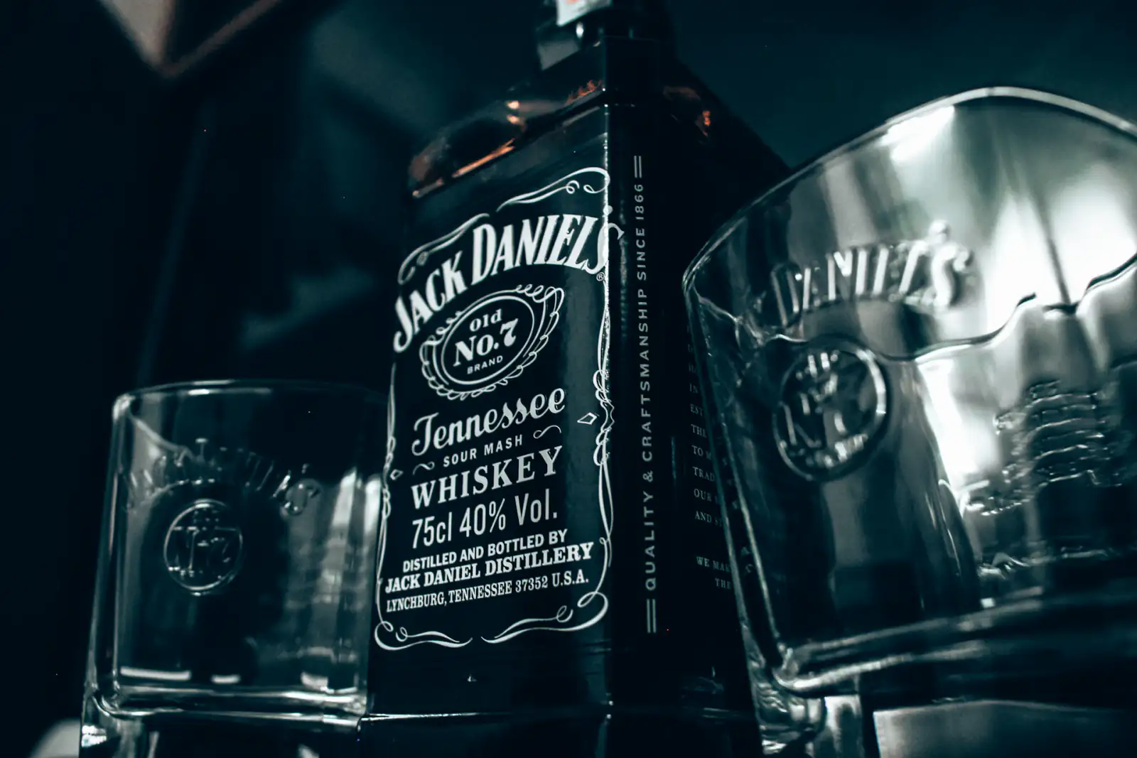 A bottle of Jack Daniel's next to two whiskey glasses